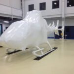 helicopter in hangar encased in white flame retardant foam prior to being shrink wrapped