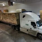 48 custom crates fully loaded and securely, uniformly fastened to the flatbed tractor trailer