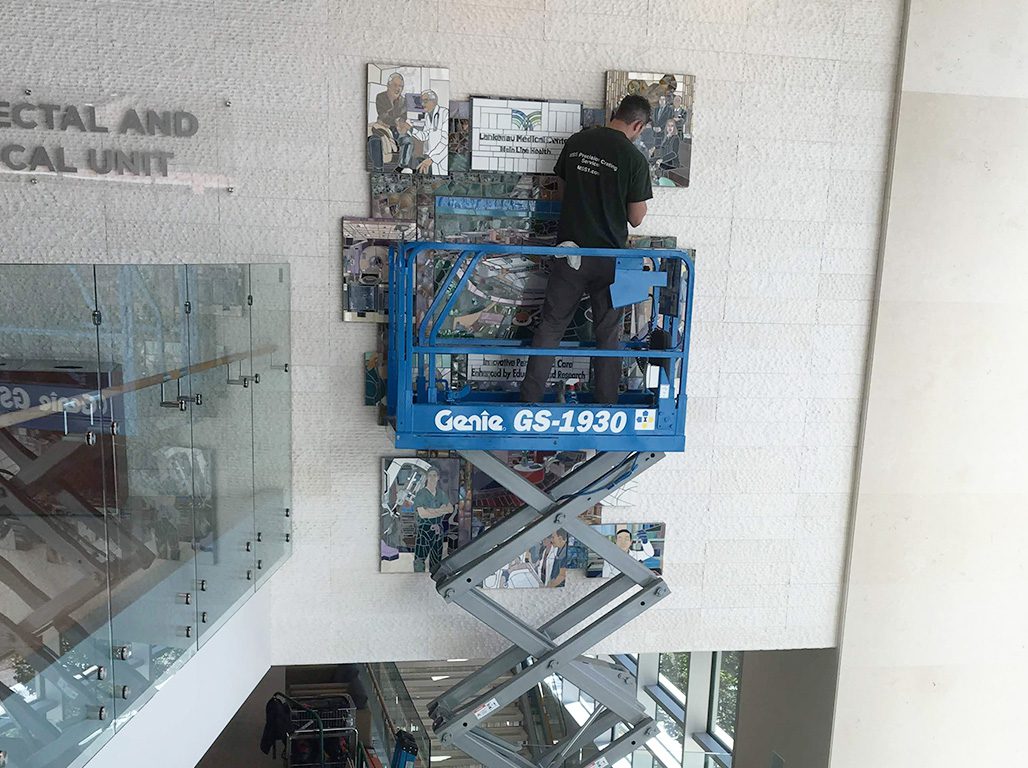 MSS crew using genie scissor lift to perform proper art installation