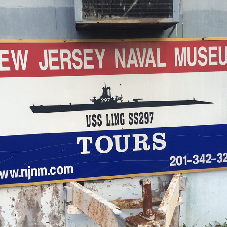 sign for the new jersey naval museum with ship image, website, and phone number